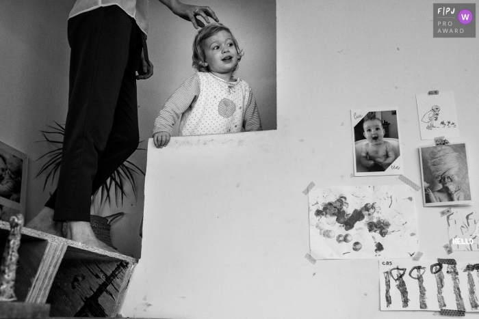 Flanders at home Day in the Life photography in BW showing a child climbing the stairs with a parent Flanders at home Day in the Life photography in BW showing a child climbing the stairs with a parent