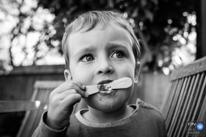 Photo by: <a href="https://www.fpja.com/documentary-family-photography-contests/alice-chapman/cambridgeshire/2111513">Alice Chapman - United Kingdom</a> Day in the Life Cambridgeshire, England documentary family photography session showing a boy eats last of ice cream