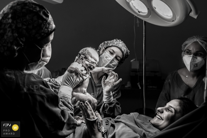 Photographie de naissance à l'hôpital Plantadores de Cana en noir et blanc d'une mère regardant son nouveau-né