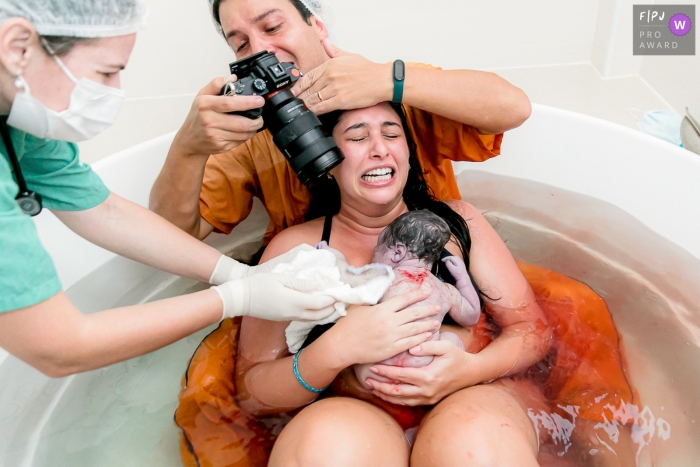 Moment-driven Hospital e Maternidade São Luiz photographie de naissance d'un couple dans une baignoire d'accouchement avec le père prenant des photos en gros plan