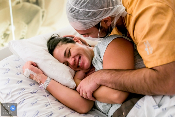 Moment Driven Hospital e Maternidade São Luiz photojournalisme de naissance image d'un couple s'embrassant avec le sourire le jour de la naissance de leur bébé