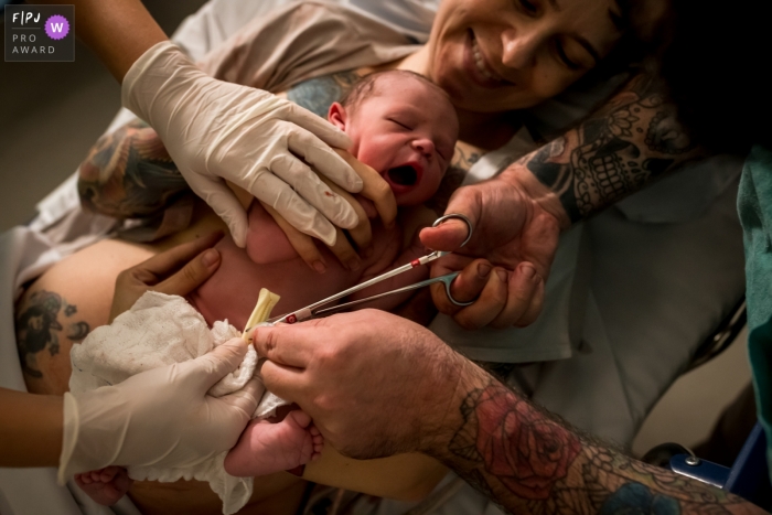 Moment-driven Hospital Samaritano birth photography capturing the father's cut of the cord Moment-driven Hospital Samaritano birth photography capturing the father's cut of the cord