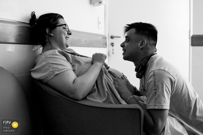 Moment-driven Maternidade Ilha birth photography with husband and wife in a chair at the hospital