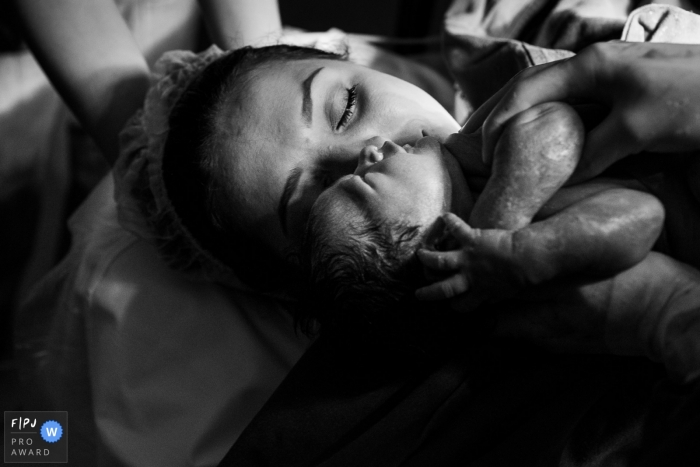 Photographie de naissance de Maternidade Ilha animée par le moment en BW de l'arrivée du bébé