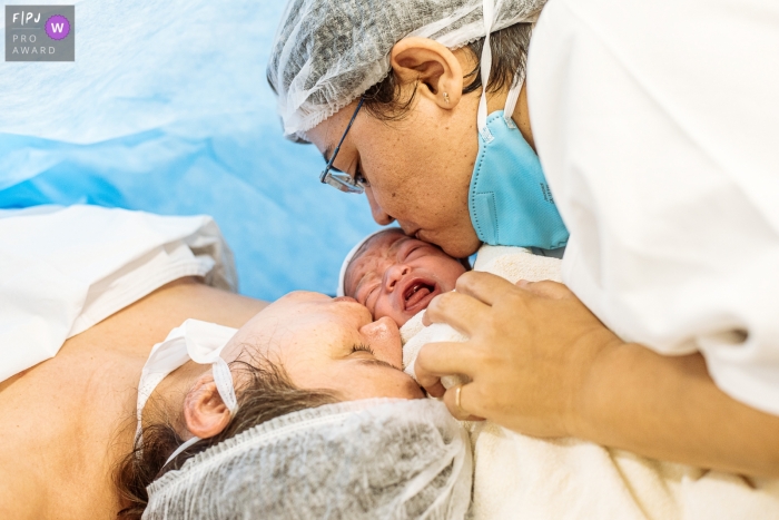 Moment entraîné Maternidade Perinatal Barra naissance photojournalisme image montrant couple kissing baby Moment entraîné Maternidade Perinatal Barra naissance photojournalisme image montrant couple kissing baby