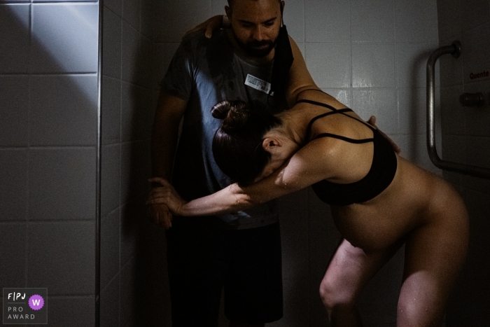 Moment driven Sao Paulo birth photojournalism image capturing the fellowship in the shower Moment driven Sao Paulo birth photojournalism image capturing the fellowship in the shower