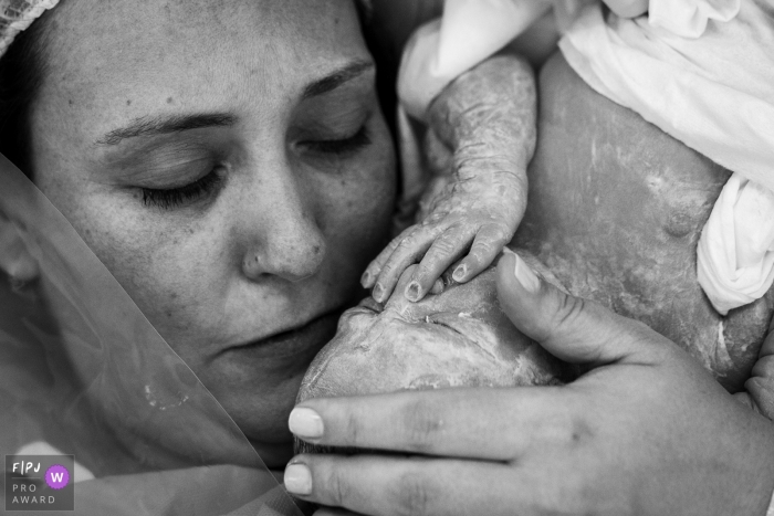 Moment-driven Hospital Pro Matre birth photography capturing the mother kissing the newborn daughter Moment-driven Hospital Pro Matre birth photography capturing the mother kissing the newborn daughter