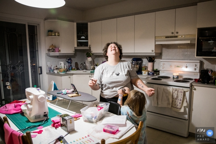 Photographie de famille à Montréal. Cette image fait partie d'une série que j'ai réalisée sur les foyers de mères célibataires pendant la pandémie de Covid-19. Il montre la réalité de leur vie quotidienne, de leur routine et de la relation avec leurs enfants. Maman et fille dans une soirée de jeu