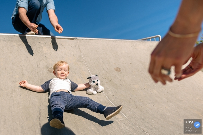 Photographie de famille à Kingston d'une mère et d'un père jouant au skatepark avec leur tout-petit