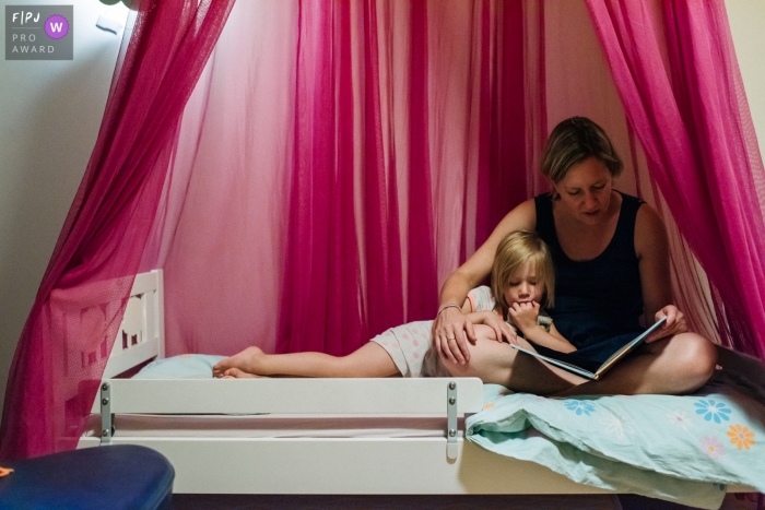 Photo by: <a href="https://www.fpja.com/documentary-family-photography-contests/viara-mileva/kingston/2112072">Viara Mileva - Canada</a> Moment-driven Kingston family photography capturing a mother reading to her daughter before bed