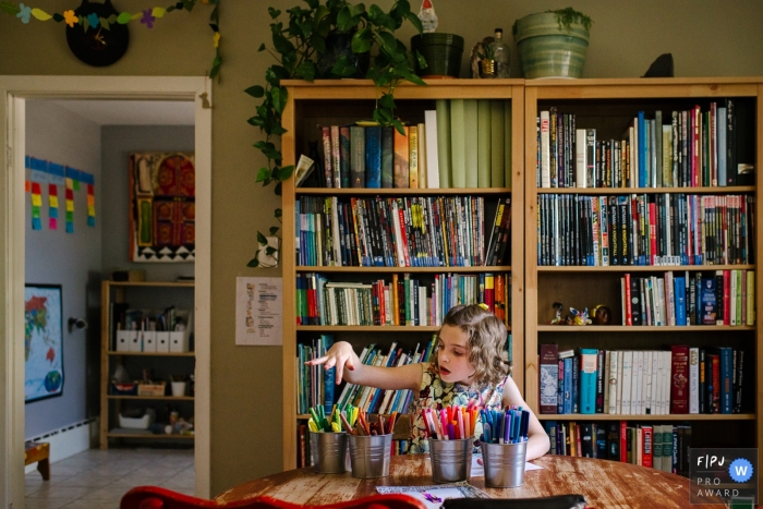 Photographie de famille à Kingston capturant une jeune fille alors qu'elle choisit son prochain crayon