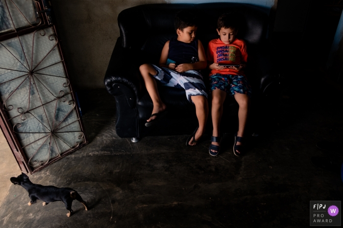 Photographie de famille Roraima axée sur le moment capturant des frères assis sur le canapé ensemble