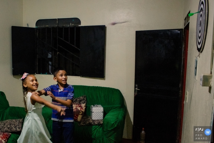 Photo by: <a href="https://www.fpja.com/documentary-family-photography-contests/jucelino-meryman/roraima/2112126">Jucelino Meryman - Brazil</a> Moment-driven Roraima family photography of siblings playing darts