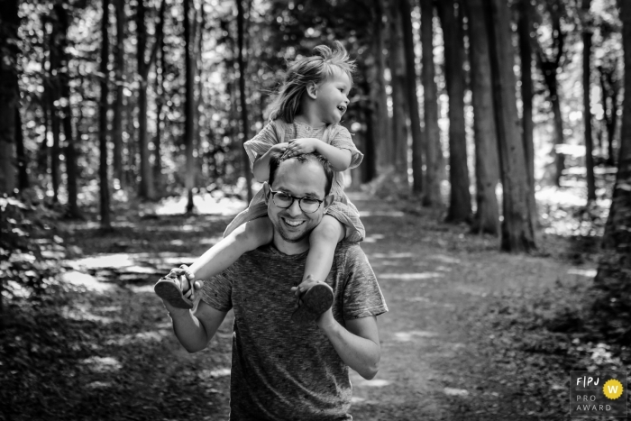 Photographie de famille limbourgeoise animée par le moment couvrant une randonnée avec papa portant sa fille sur ses épaules