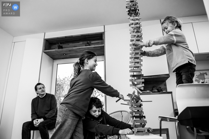 Image de photojournalisme familial de Wallonie motivée par le moment d'une tour kapla renversée