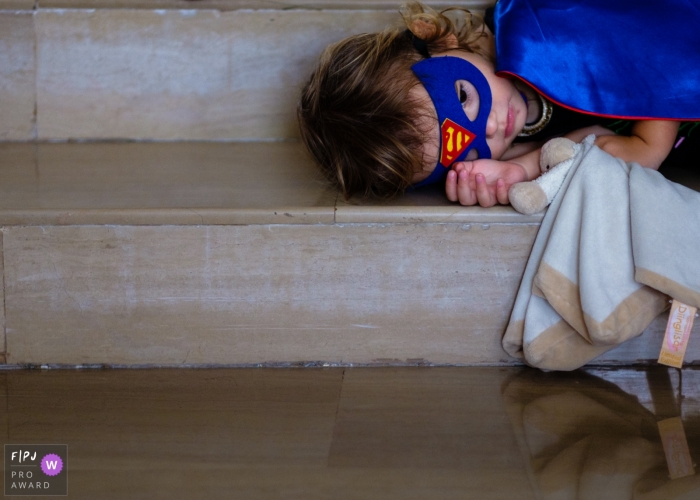 Moment driven Germany family photojournalism image showing a very tired superhero