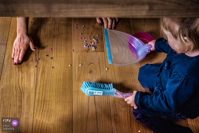 Moment driven Dusseldorf family photojournalism image of a girl helping mom to clean up Moment driven Dusseldorf family photojournalism image of a girl helping mom to clean up