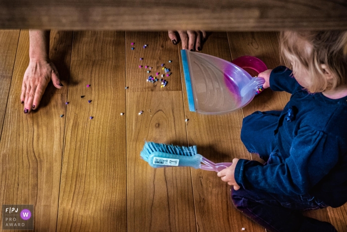 Moment driven Dusseldorf family photojournalism image of a girl helping mom to clean up