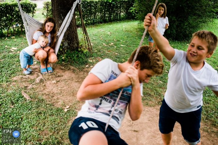 Moment-driven Ljubljana family photography of kids having fun on hammocks and swings