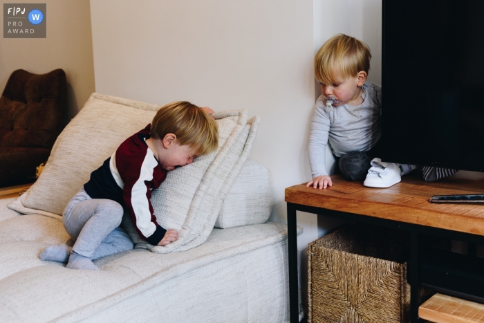 Amsterdam family photojournalism image Twin brothers around the TV-screen, one of them is enjoying himself, the other not so much Moment driven Amsterdam family photojournalism image Twin brothers around the TV-screen, one of them is enjoying himself, the other not so much