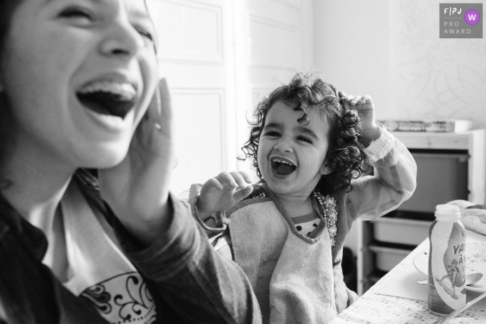 Moment driven Paris family photojournalism image of a laughing session at the meal table Moment driven Paris family photojournalism image of a laughing session at the meal table