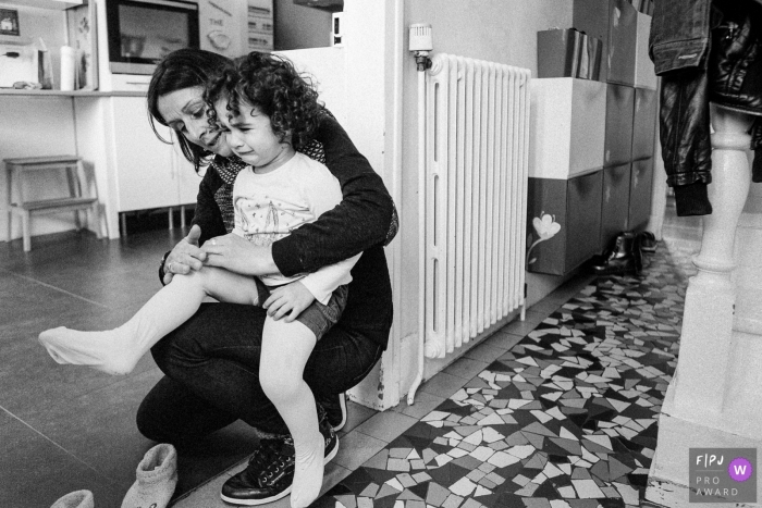 Moment-driven Ile-de-France family photography of a little girl crying on her mom's knees Moment-driven Ile-de-France family photography of a little girl crying on her mom's knees