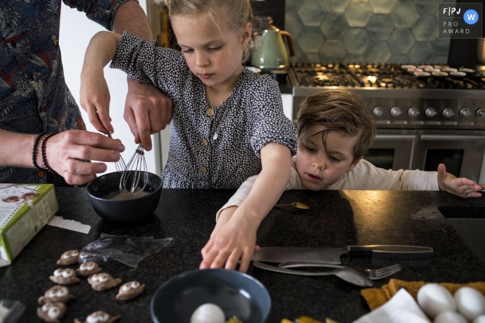 Photographie de famille Drenthe animée par un moment d'une famille cuisinant dans la cuisine avec les mains tendues