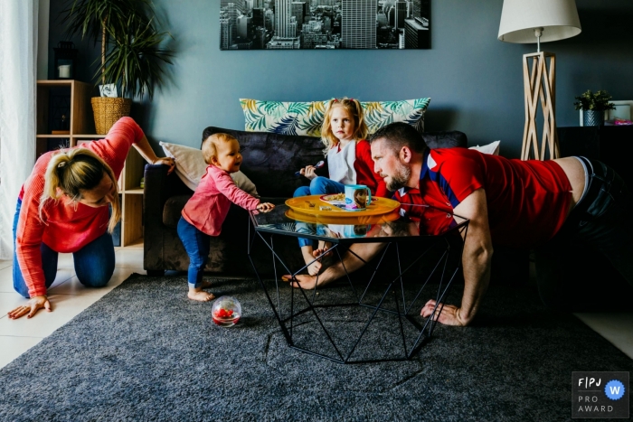 Moment driven Var family photojournalism image capturing the seeking of an object that has disappeared in the livingroom