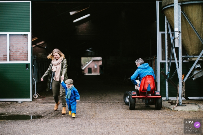 Netherlands family photography of a mother and child exiting a barn on their vaction on the farm Moment-driven Netherlands family photography of a mother and child exiting a barn on their vaction on the farm
