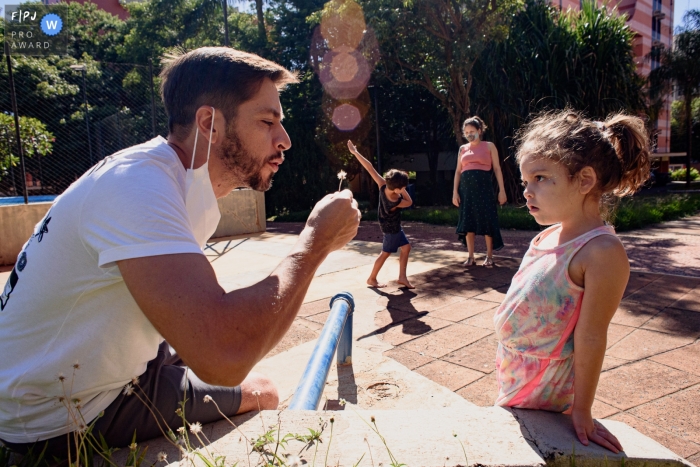 Photographie de famille à Sao Paulo d'une mère, d'un père et d'enfants jouant ensemble à l'extérieur