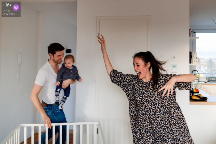 Moment driven Hesse family photojournalism image of mom, dad and baby Playing around together