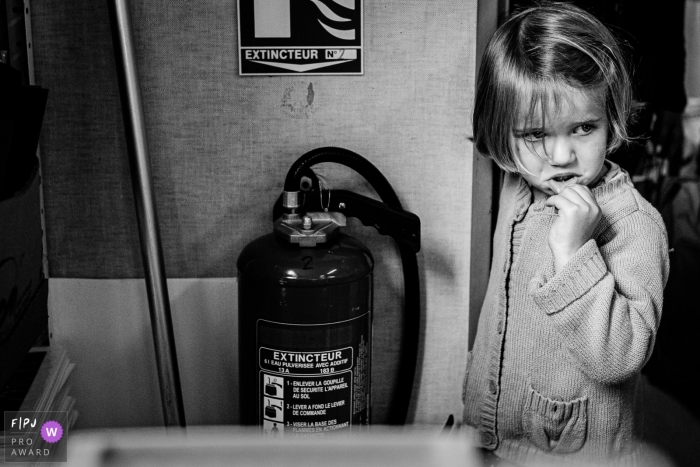 Moment driven Occitanie family photojournalism image in BW of a shy girl at school