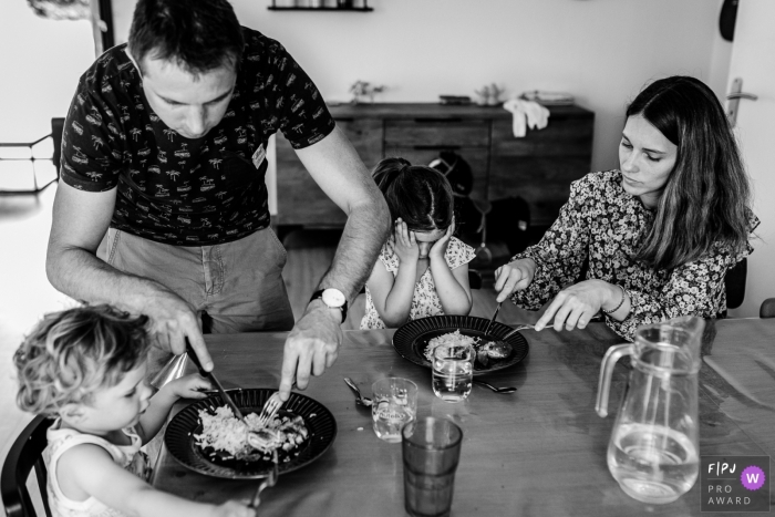 Image de photojournalisme familial de Haute-Garonne animée par un moment à partir d'un repas à table