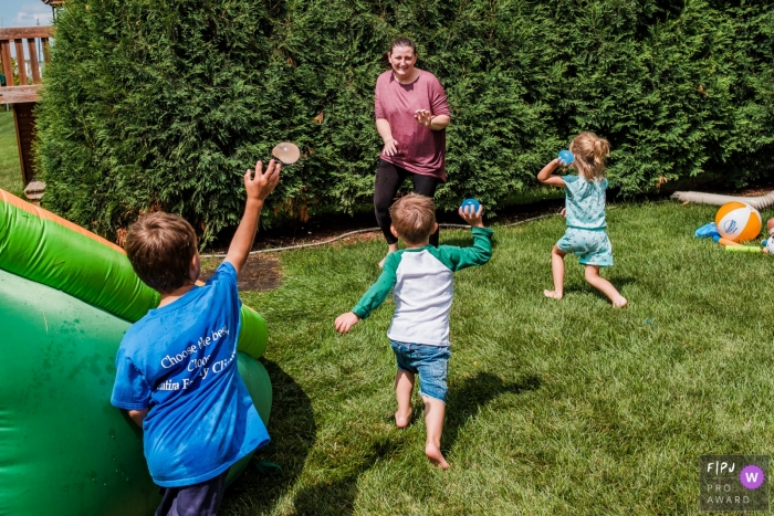 Moment-driven San Francisco backyard family photography in the backyard during a water balloon fight Moment-driven San Francisco backyard family photography in the backyard during a water balloon fight