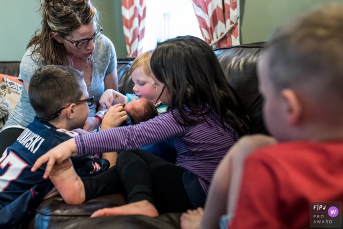 Image de photojournalisme familial du Connecticut animée par un moment montrant l'inspection du nouveau bébé que maman vient de ramener de l'hôpital