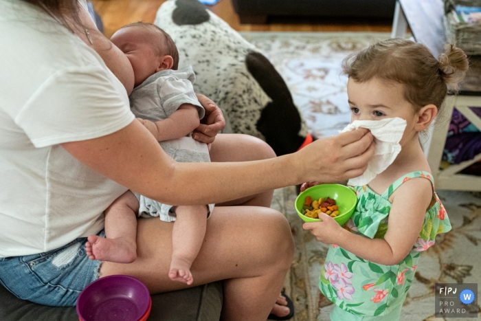 Photographie de famille dans le Connecticut avec une maman multitâche s'essuyant un petit nez