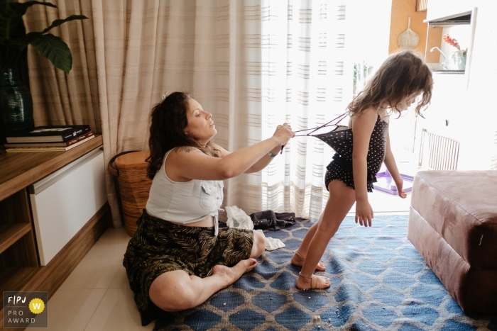 Moment-driven Florianopolis, SC family photography from the moment when Mother is trying to put her daughter's bathing suit on to go to the beach Moment-driven Florianopolis, SC family photography from the moment when Mother is trying to put her daughter's bathing suit on to go to the beach