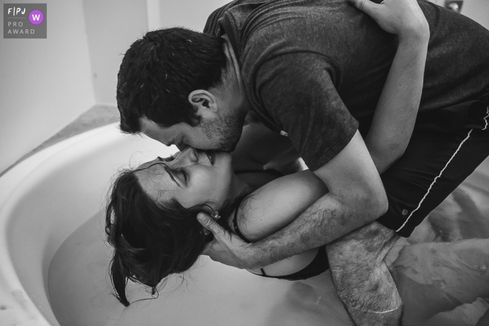Belo Horizonte father holds his wife carefully, showing her love during her painful labor in a birth tub Belo Horizonte father holds his wife carefully, showing her love during her painful labor in a birth tub