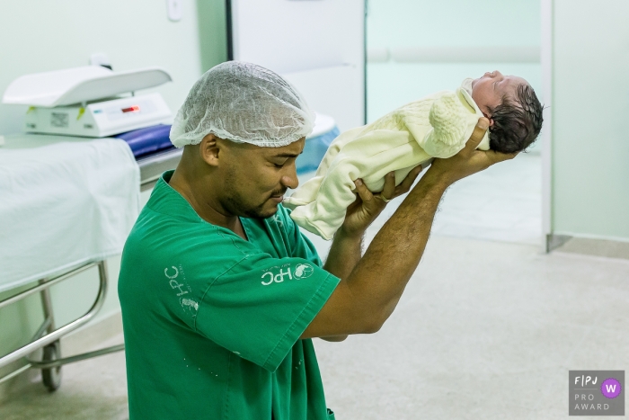 Photographie de naissance de l'hôpital Plantadores de Cana montrant le père consacrant le fils