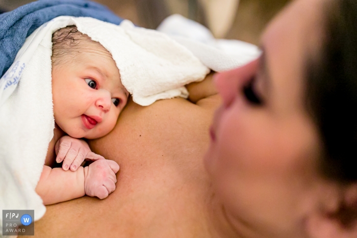 Hospital e Maternidade São Luiz birth image of a newborn looking wide-eyed at his mother Hospital e Maternidade São Luiz birth image of a newborn looking wide-eyed at his mother