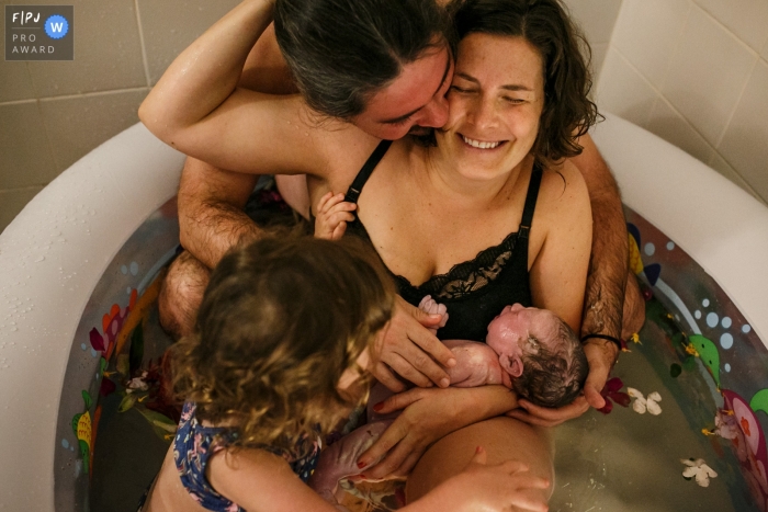 Belo Horizonte Hausgeburtsfoto der ganzen Familie, die direkt nach der Geburt des zweiten Kindes zu Hause emotional umarmt