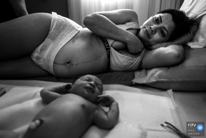 Cuiabá mother filled with a quite emotion lays on the bed with her newly born infant Cuiabá mother filled with a quite emotion lays on the bed with her newly born infant