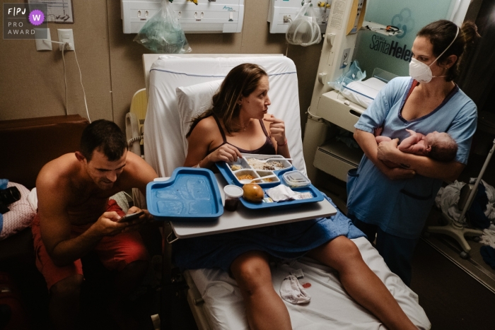 Maternidade Santa Helena hospital image of a moment of postpartum, in the maternity bed with a doctor with baby and mother and father on the cell phone telling about the birth of their daughter Maternidade Santa Helena hospital image of a moment of postpartum, in the maternity bed with a doctor with baby and mother and father on the cell phone telling about the birth of their daughter
