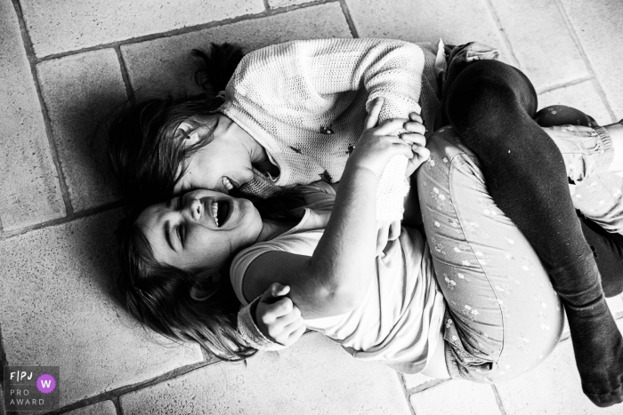 Wallonie family image of sister having fun on the floor Wallonie family image of sister having fun on the floor