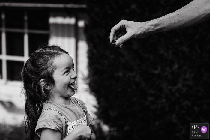 Belgium young girl makes a face as a snail is shown to her Belgium young girl makes a face as a snail is shown to her