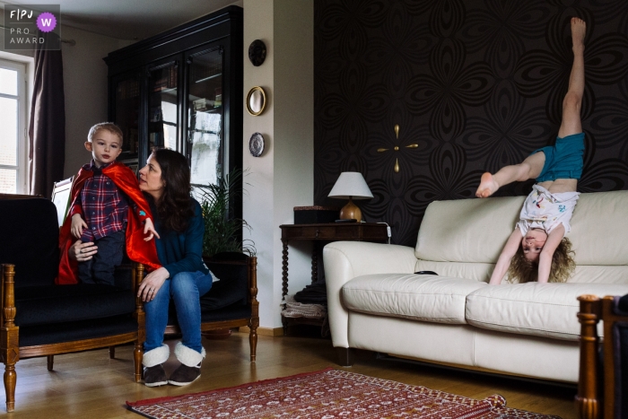 Paris family photography of mom with kids, one doing gymnastics in the living room Paris family photography of mom with kids, one doing gymnastics in the living room