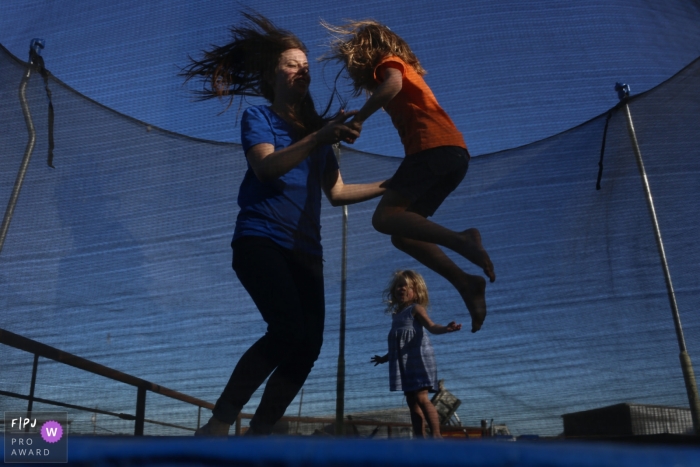 Séance photo de famille à San Francisco avec la mère et les enfants jouant dans le trampoline