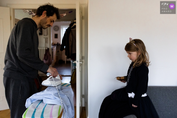 Hamburg father ironing a shirt as his daughter watches Hamburg father ironing a shirt as his daughter watches