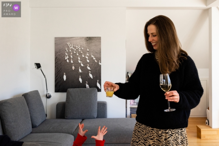 Photographie de famille de Hambourg d'une mère offrant un verre à un petit enfant avec juste leurs mains atteignant le cadre