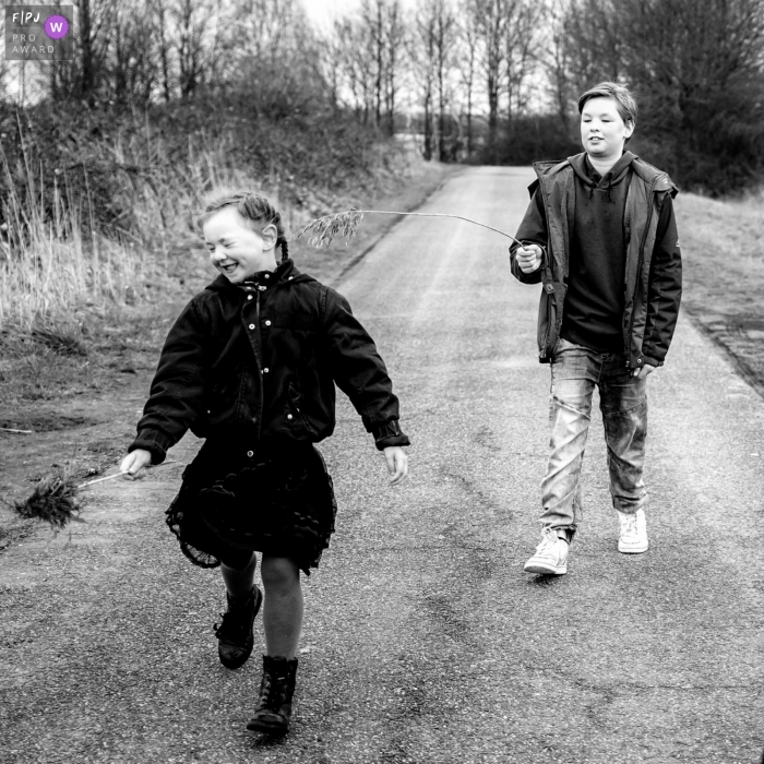 Zuid Holland brother and sister take a stroll on a chilly day during a family photo session Zuid Holland brother and sister take a stroll on a chilly day during a family photo session